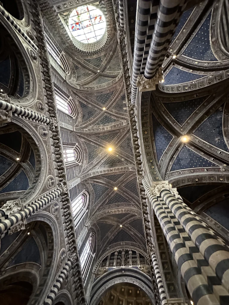 The vaulted ceilings of the Siena Cathedral  feature a blue background and gold star motif.