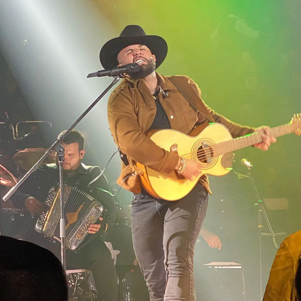 Carín León performing live with guitar at Palenque Feria San Marcos in Aguascalientes Mexico
