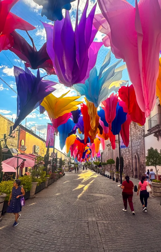 Colorful fabric decorations hanging above a street during Feria San Marcos in Aguascalientes Mexico