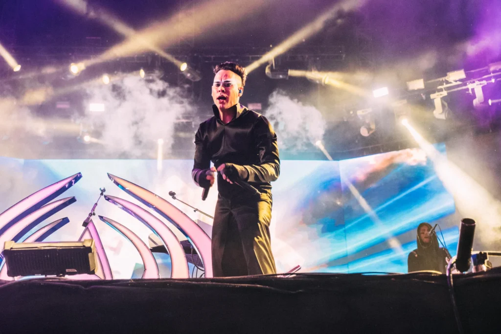 Empire of the Sun singer performing on stage with lights and visuals at Feria San Marcos in Aguascalientes