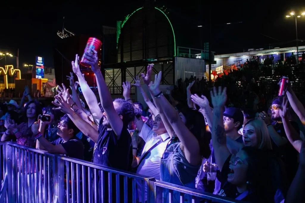 Excited crowd with raised hands during a concert at Feria San Marcos in Aguascalientes Mexico