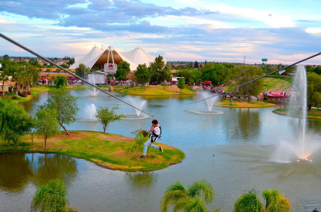 Person riding a zipline over lake at Isla San Marcos during Feria San Marcos in Aguascalientes Mexico
