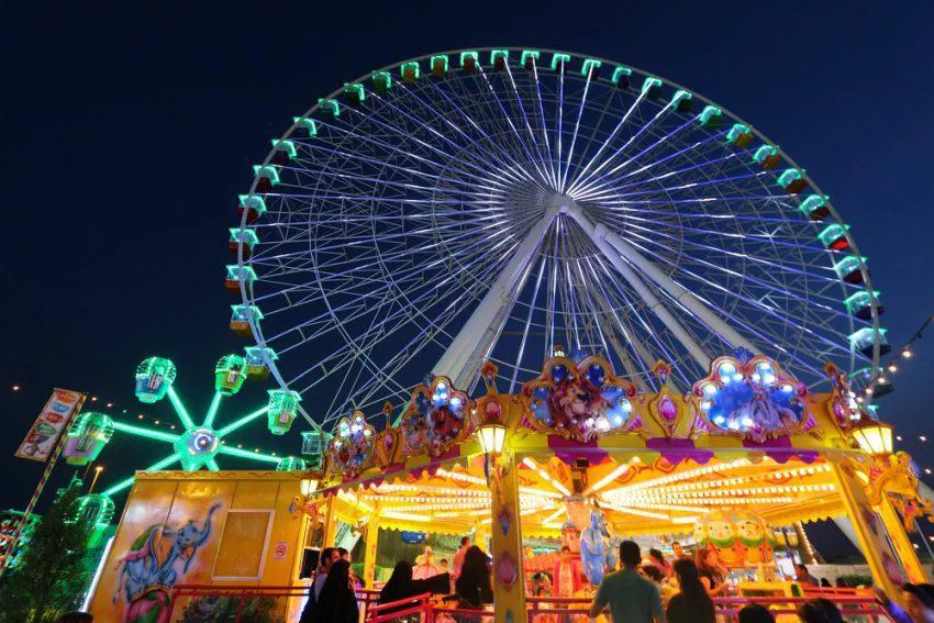 Ferris wheel and amusement rides at night during Feria San Marcos in Aguascalientes Mexico