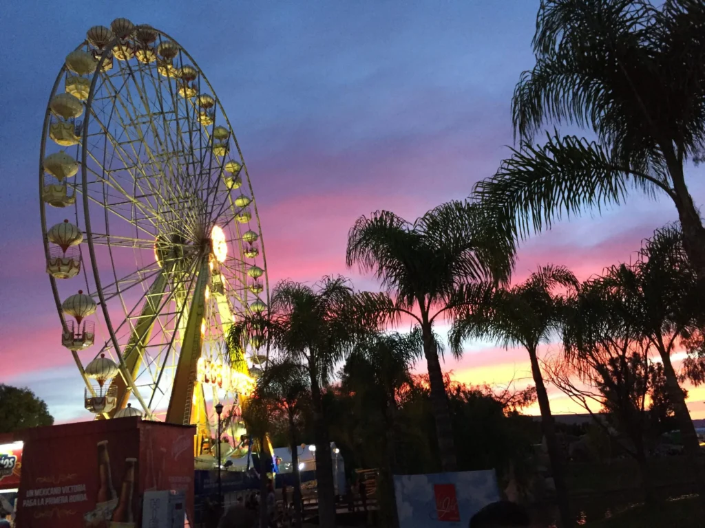 Ferris wheel at sunset with palm trees during Feria San Marcos in Aguascalientes Mexico