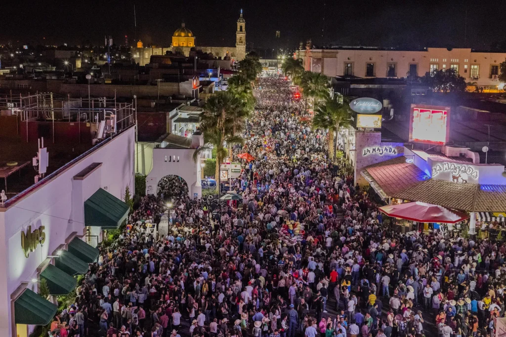 Crowded street at night during Feria San Marcos in downtown Aguascalientes Mexico