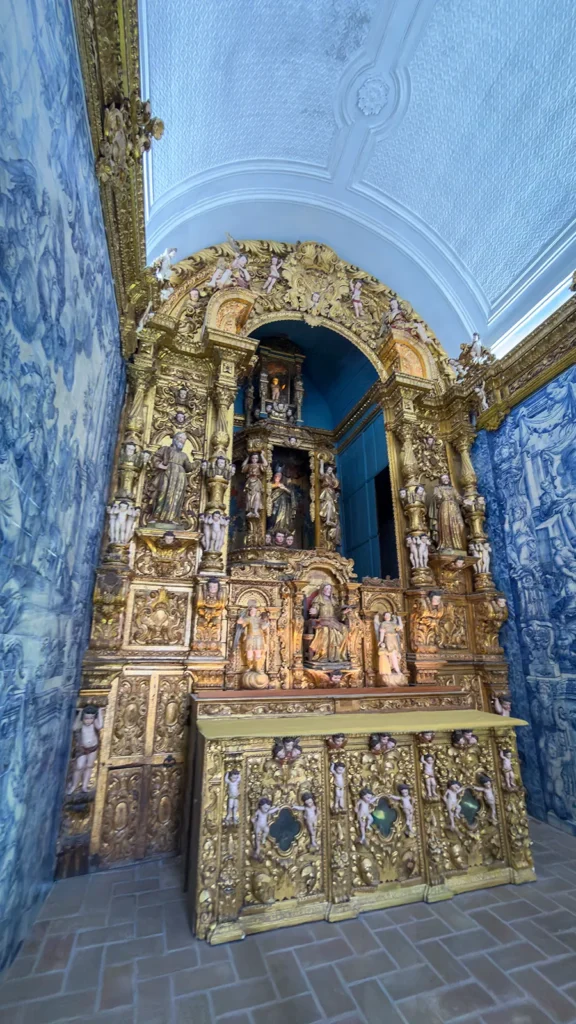 Baroque gilded altar surrounded by blue-and-white azulejo panels inside Ermida de Nossa Senhora da Conceição in Loulé, Portugal.