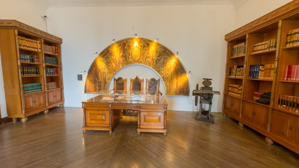 Room inside the Loulé Castle Museum with wooden bookcases, old books, display table, and historic objects