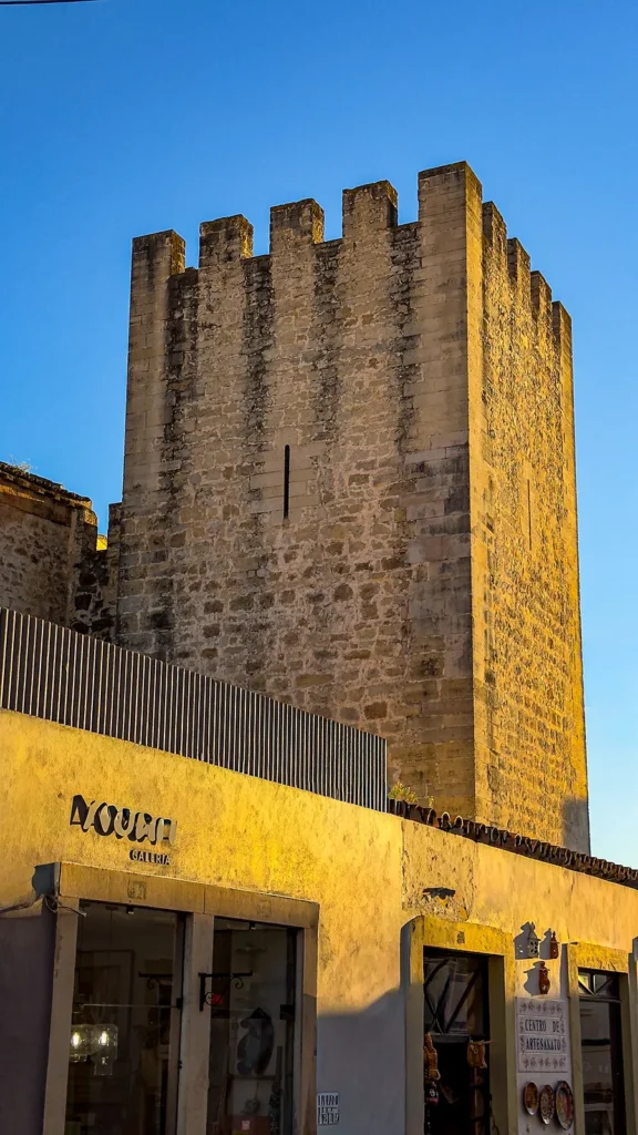 Tower of Castelo de Loulé rising above artisan shops and historic buildings in the old town.