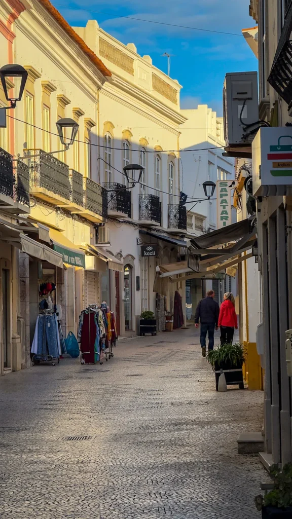 Historic shopping street with boutiques and pedestrians in Loulé Old Town.