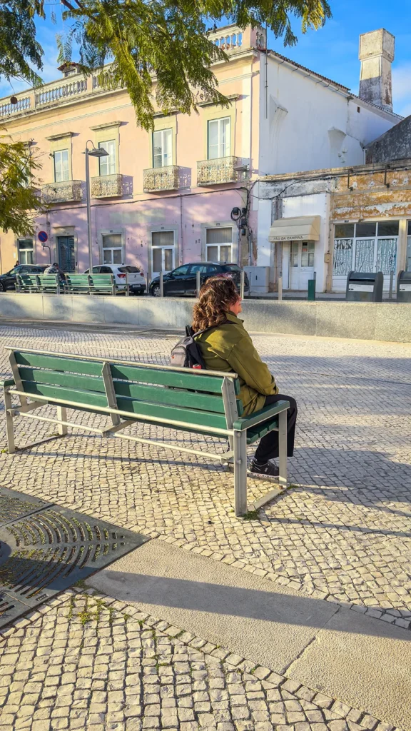 Woman sitting on a bench in Loulé Old Town on a sunny winter afternoon.