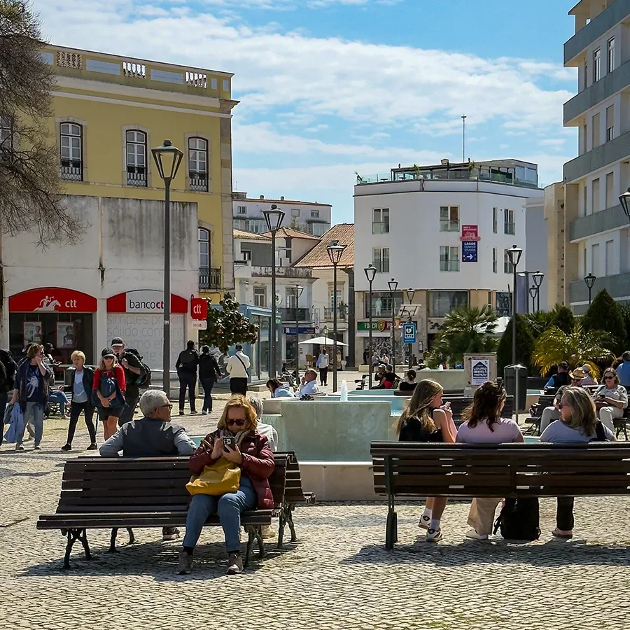 Des personnes profitant du soleil sur des bancs d’une place du centre-ville de Lagos, en plein hiver.